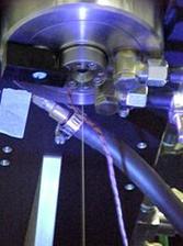 A fiber coming out of a nozzle at high speed is cured under UV light.